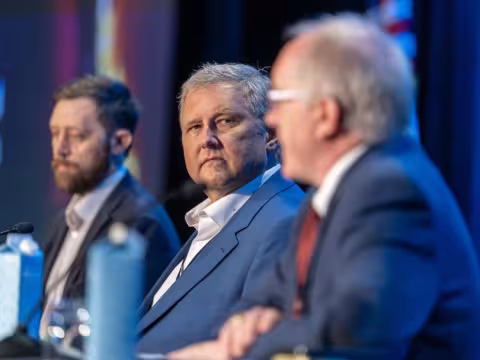 Three public safety leaders wearing business attire sit at a table with microphones during a panel discussion at 5x5
