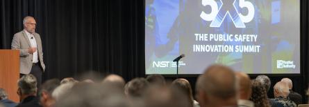 A speaker stands on the main stage at 5x5