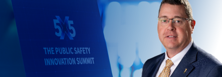 G.B. Jones, 5x5: Public Safety Innovation Summit logo on a sign in a conference hall
