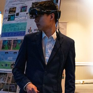 A tech demo host at 5x5 tries on VR glasses that will be used in a demo